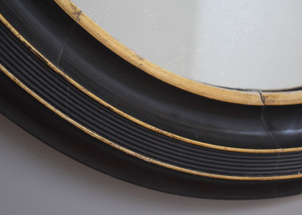 Late 19th Century French Ebonised Oval Mirror with Gold Detail